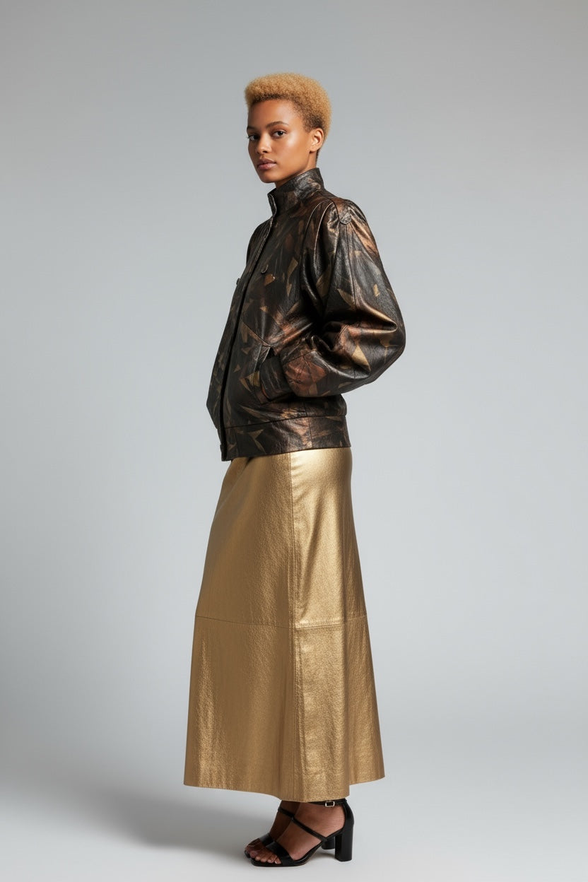 Person wearing a metallic jacket and gold skirt on a plain background