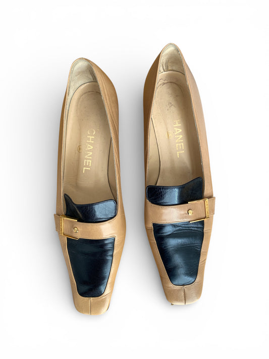 Pair of Chanel tan and brown loafers on a white background