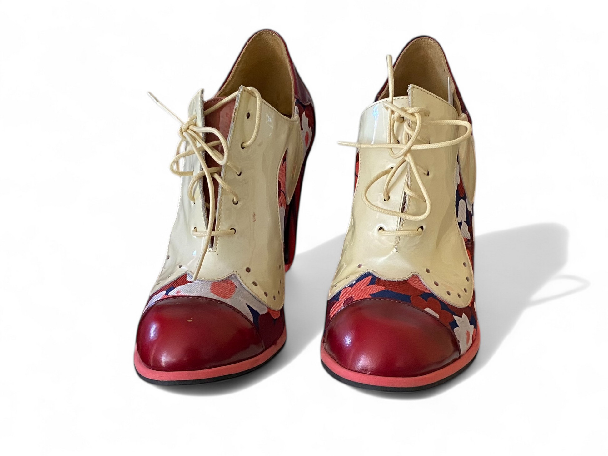 Pair of John Fluevog high-heeled shoes with floral pattern on a white background