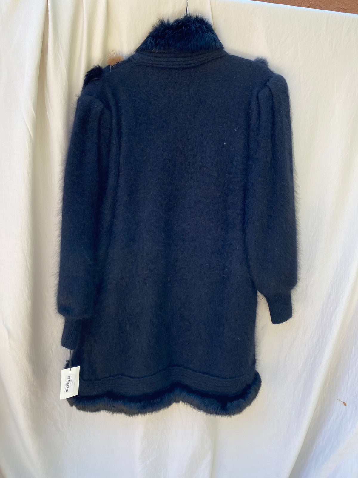 Back view of the black angora knit coat with fur trimmed hem