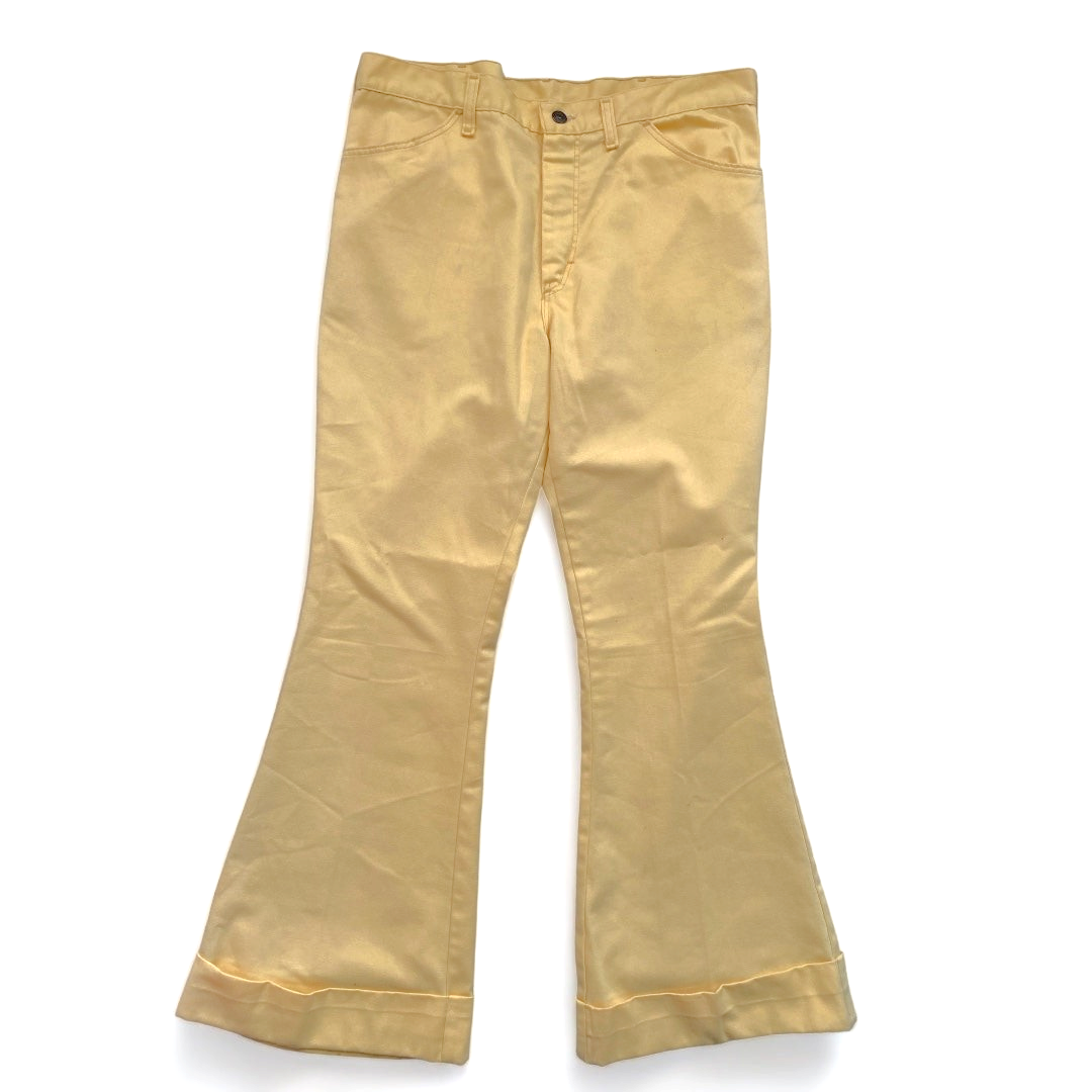 LaliSimone vintage 1970s men's low rise pastel yellow bell bottom pants with folded cuffs on a white background.