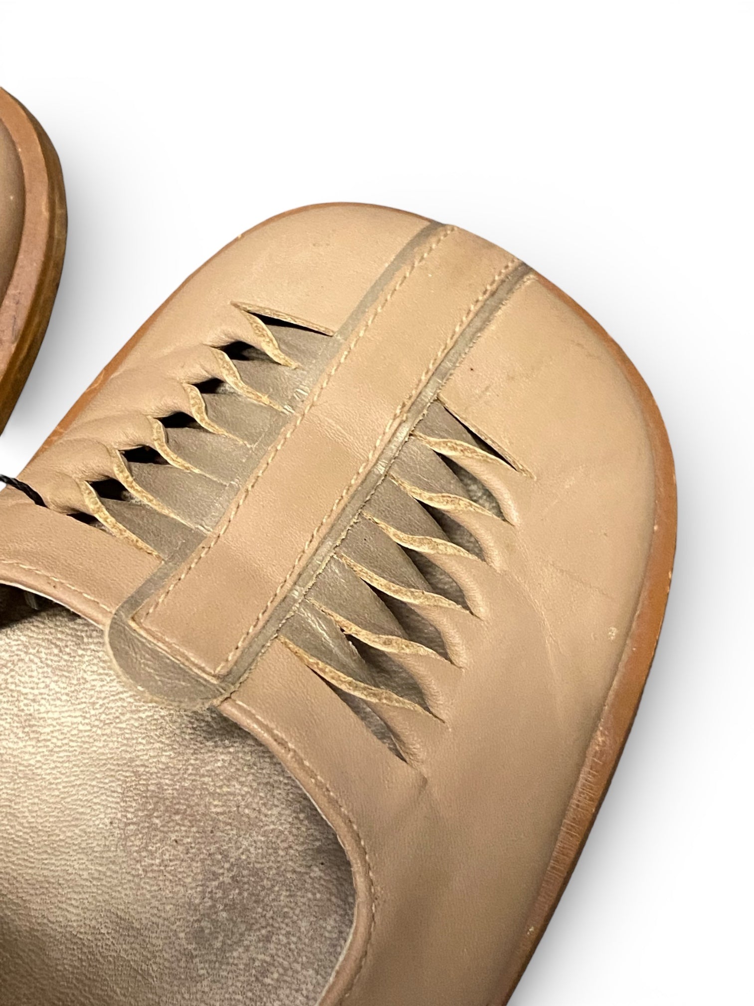 Close-up of a beige leather shoe with a white background