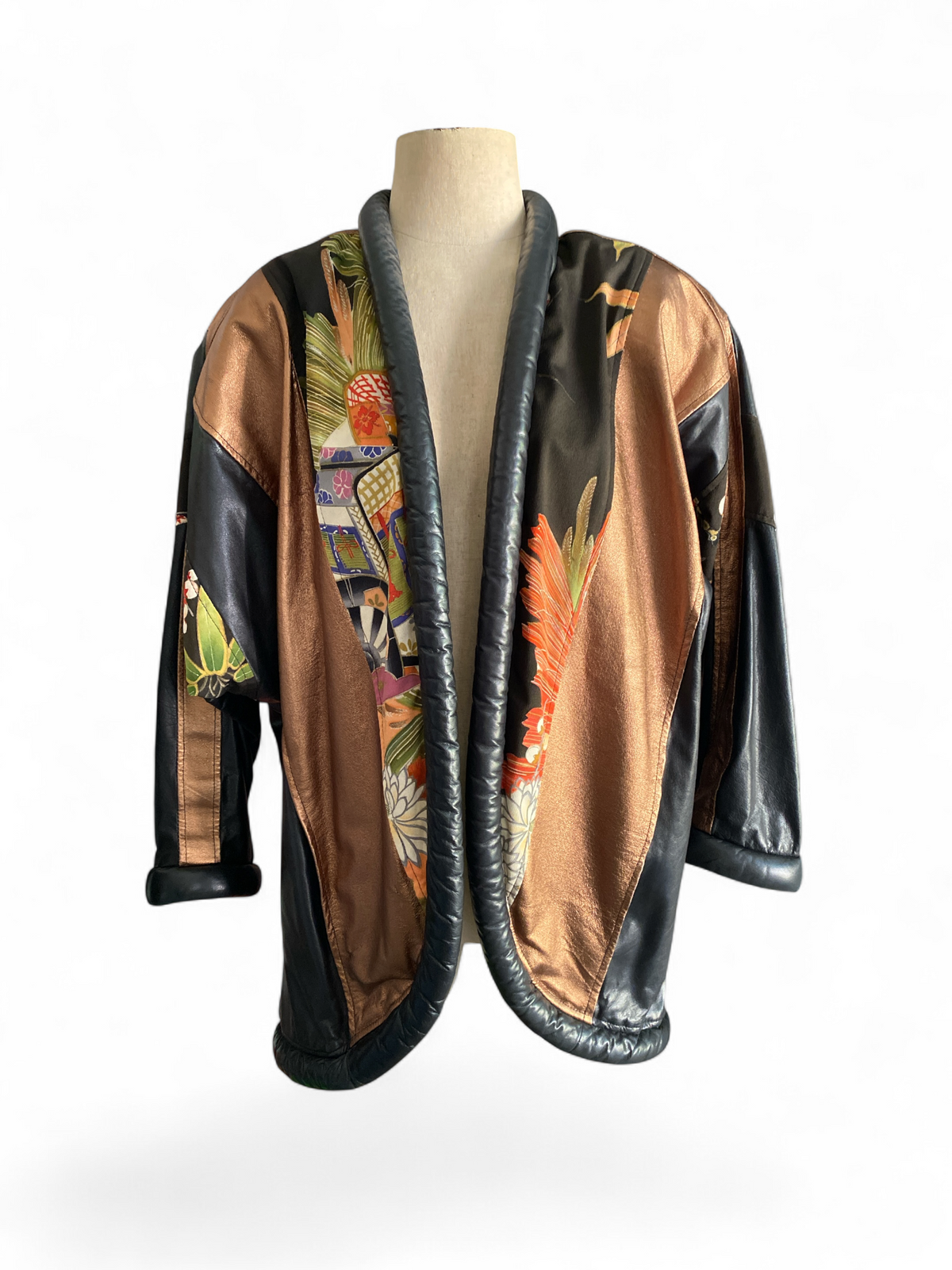 Opulent 1980s leather kimono jacket, back view, showing the bronze metallic leather panel with silk kimono fabric in floral and fan motifs down the center back and cherry blossom silk patches on the sleeves