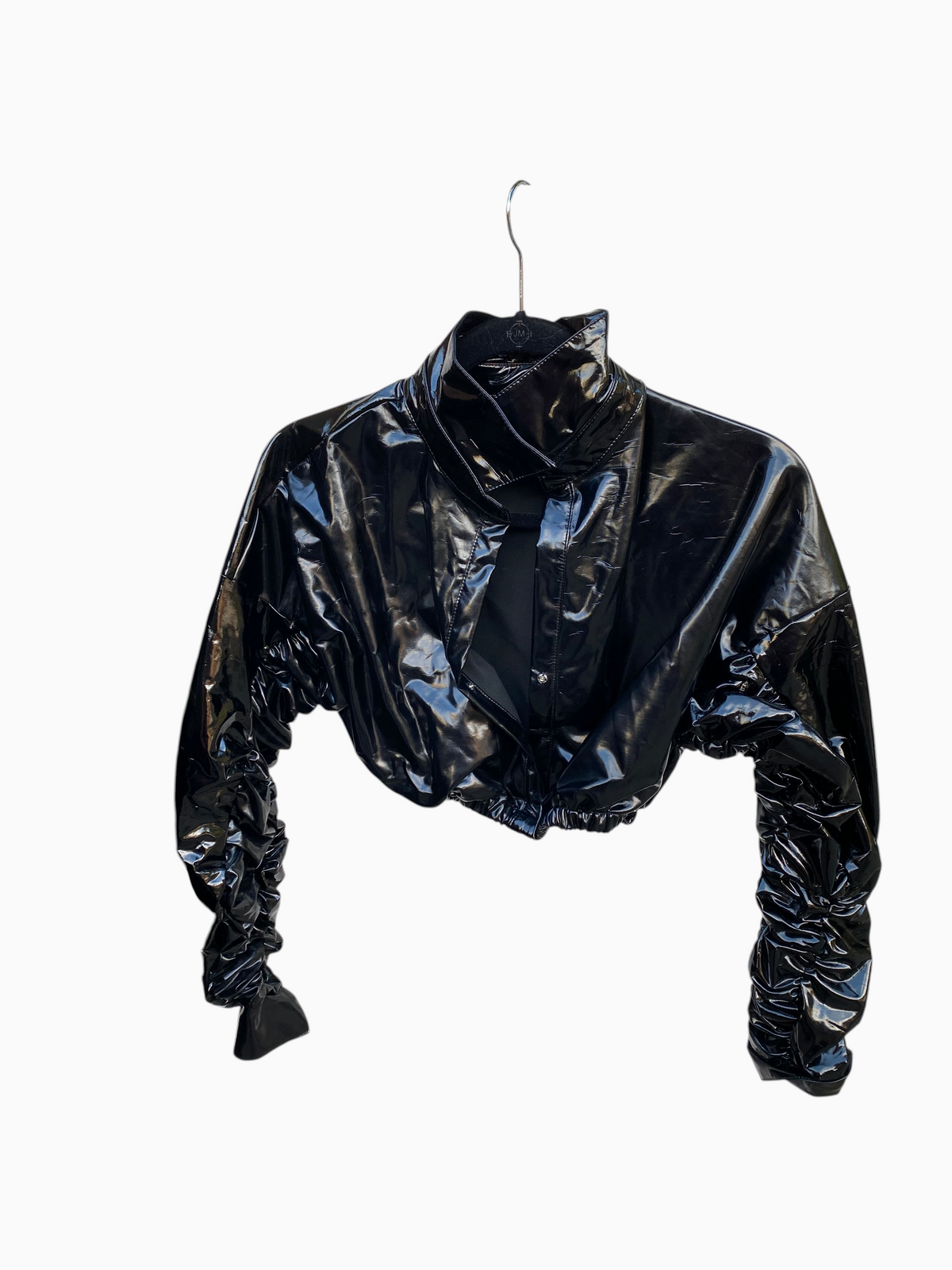 LaliSimone black shiny PU cropped jacket with a plunging collar and dramatic ruched long sleeves on a hanger