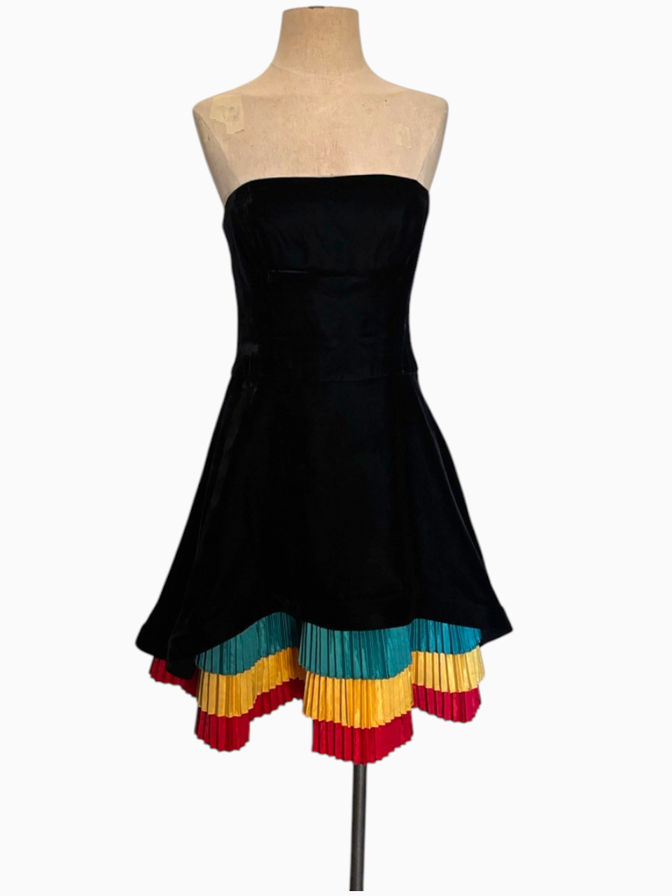 LaliSimone black velvet cocktail dress featuring a strapless bodice and multi-colored knife-pleated layered hem.