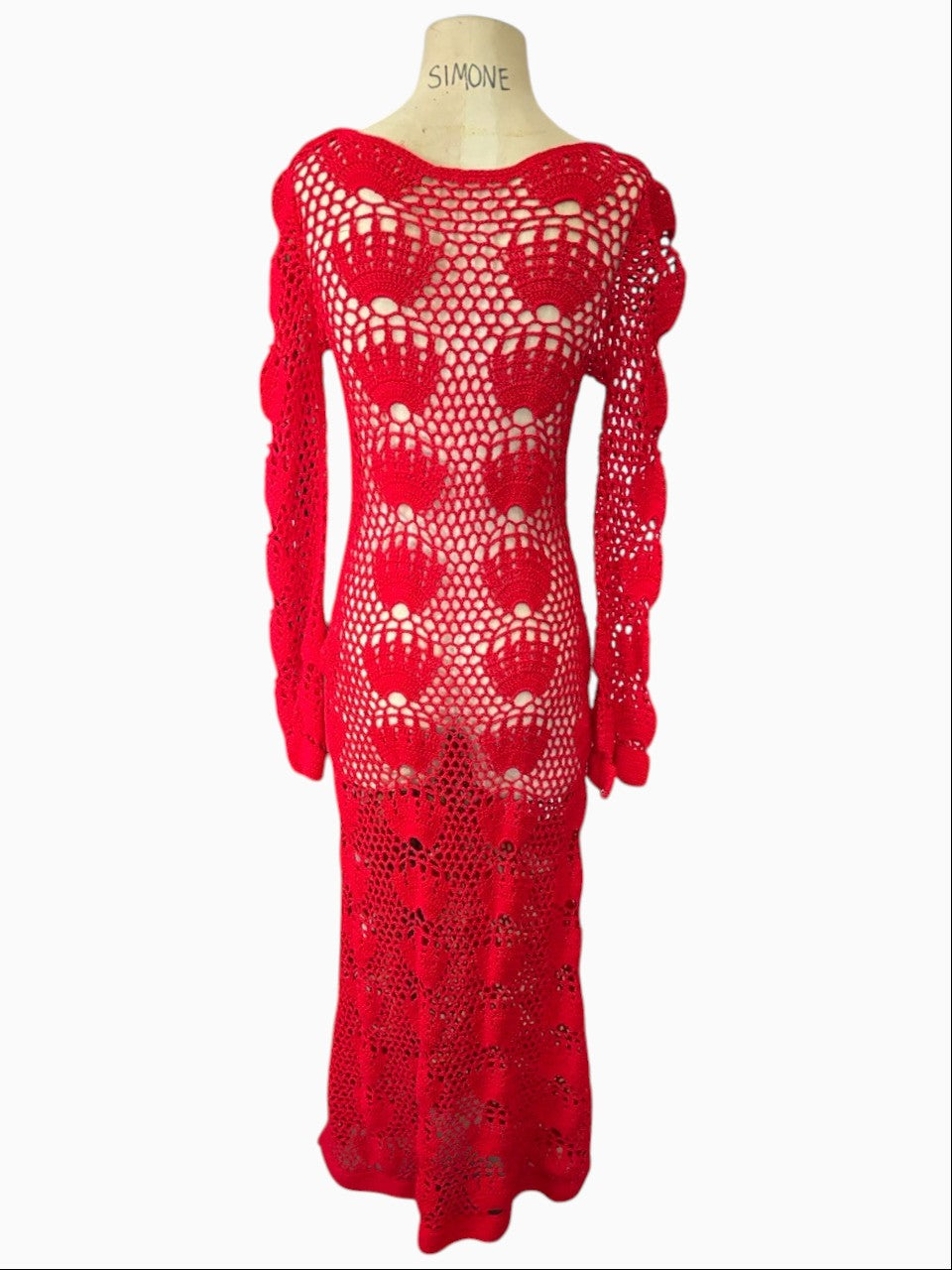 LaliSimone red crochet maxi dress with intricate openwork, long sleeves, and bell cuffs on a dress form.