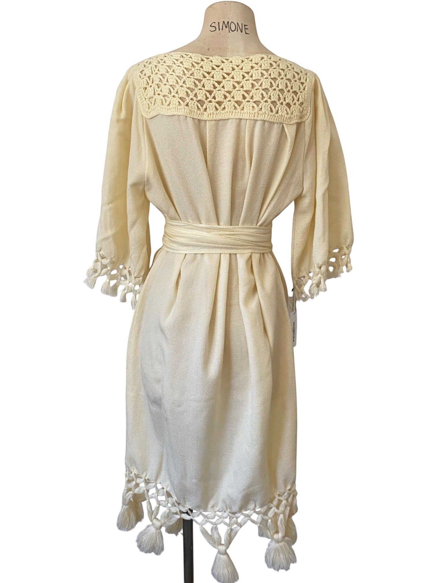 LaliSimone cream boho dress with crochet neckline, belt, and tassel hem. 3/4 sleeves.