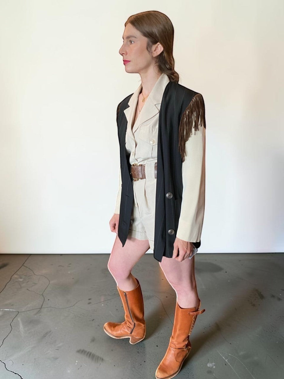 LaliSimone Ozbek striped jacket with brown fringe detail over a cream utility romper and brown boots.
