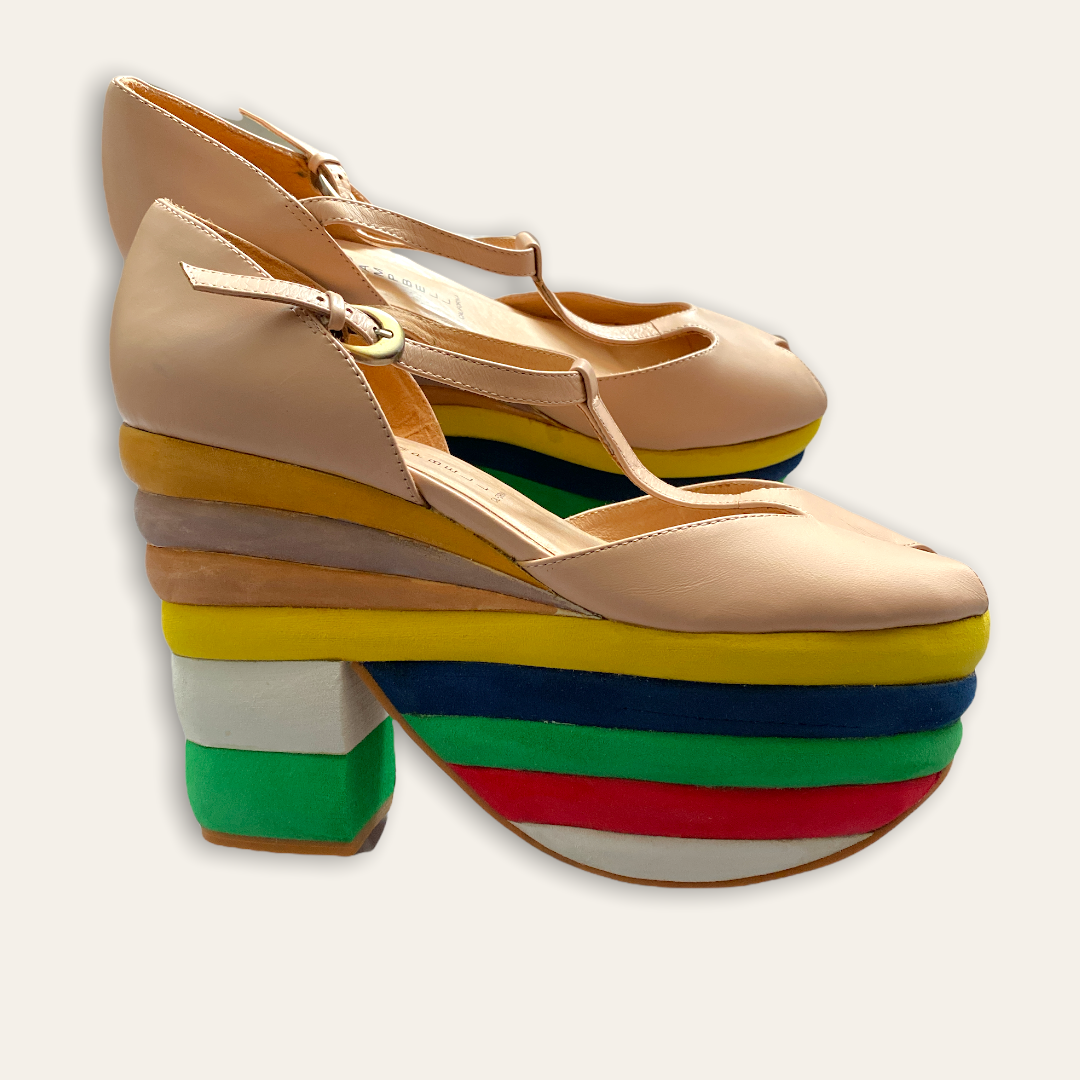 A pair of tan-colored, platform heel shoes with a rainbow layered design on the heel, featuring a peep toe style.